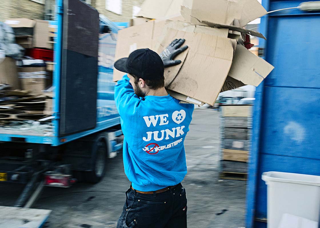 Junkbusters-Mitarbeiter transportiert Kartonagen zur umweltfreundlichen Entsorgung.